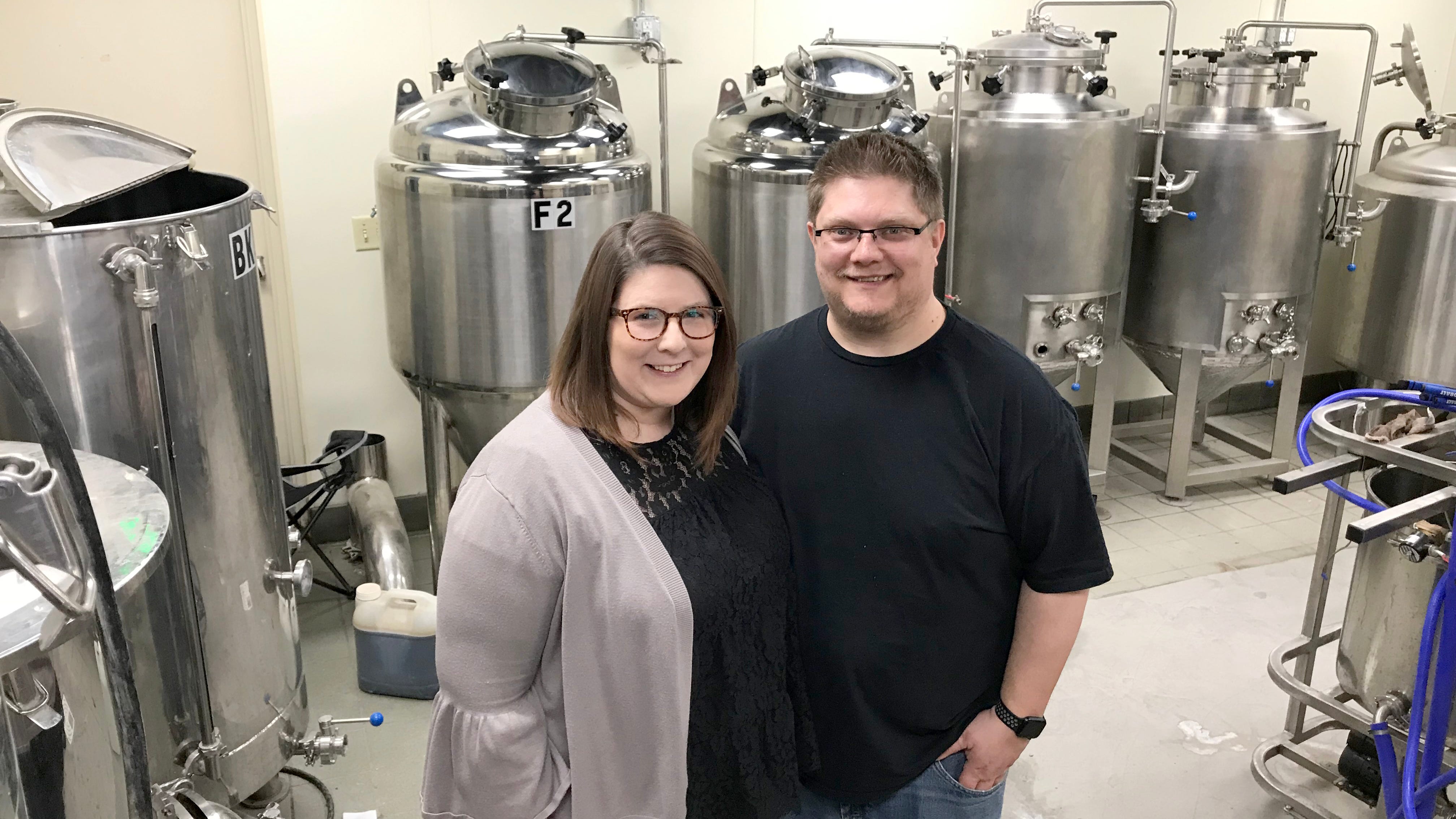 Business owners Amber and Brian Buss stand in the production area of Bust'd Brewery.