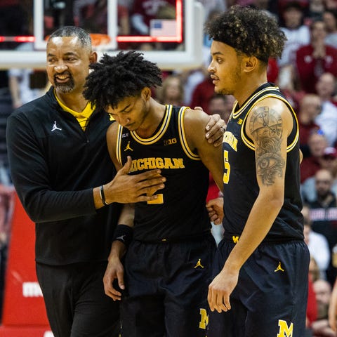 Michigan coach Juwan Howard leads his players off 