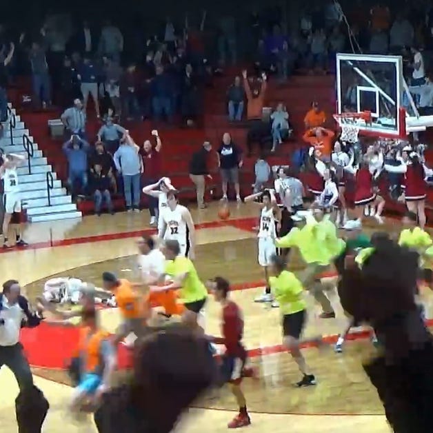 Illini Bluffs players stand, hands on their heads in disbelief, as the crowd storms the court around them after Gibrault got a buzzer-beater 3 from Kameron Hanvey to beat IB, 45-44, in the IHSA Class 1A Supersectional at Jacksonville on Monday, March 6, 2023.