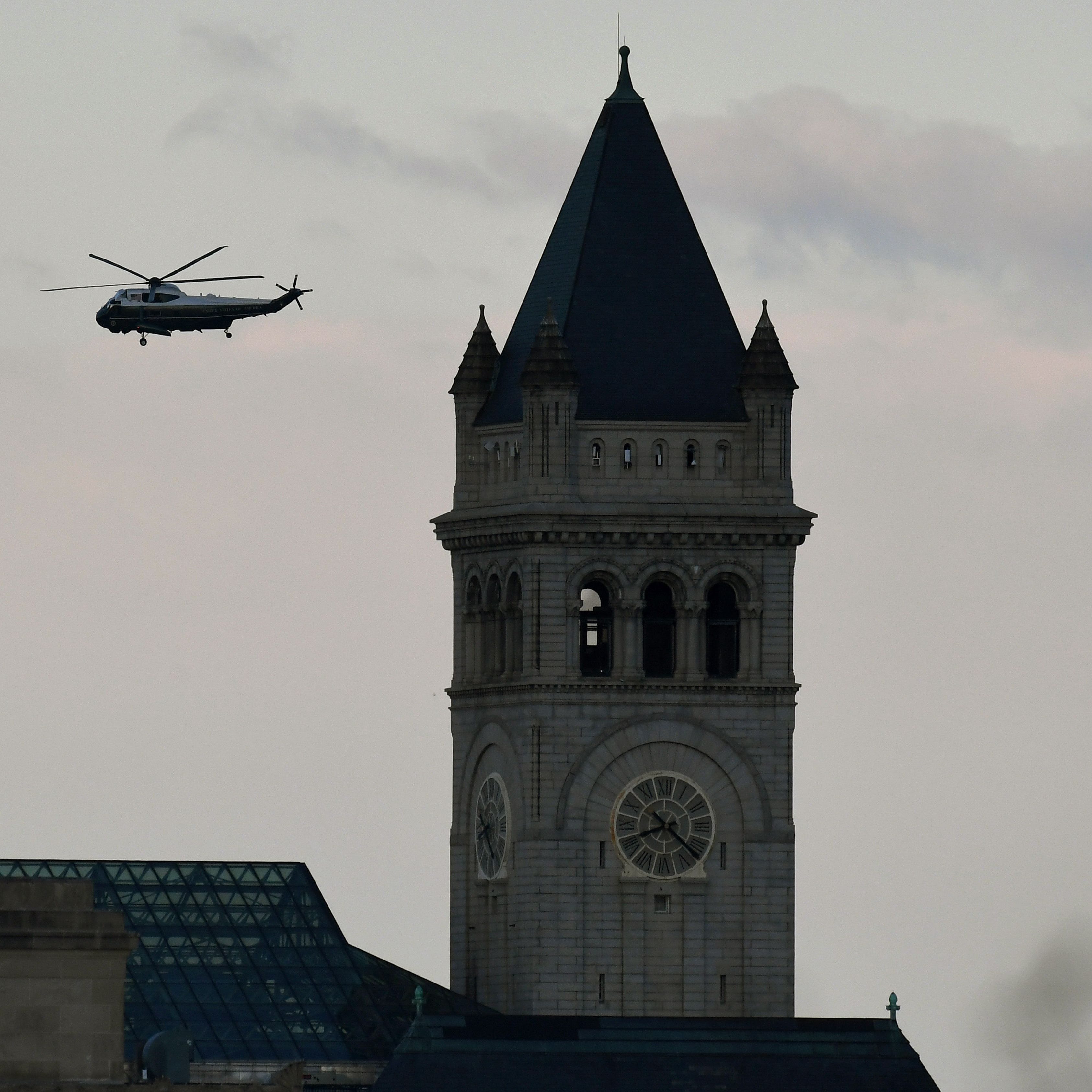 Marine One with US President Donald Trump and First Lady Melania Trump passes the Trump International Hotel (R)  as it departs the White House in Washington, DC, on January 20, 2021. - President Trump travels to his Mar-a-Lago golf club residence in Palm Beach, Florida, and will not attend the inauguration for President-elect Joe Biden. (Photo by OLIVIER DOULIERY / POOL / AFP) (Photo by OLIVIER DOULIERY/POOL/AFP via Getty Images) ORG XMIT: 0 ORIG FILE ID: AFP_8Z69Y6.jpg