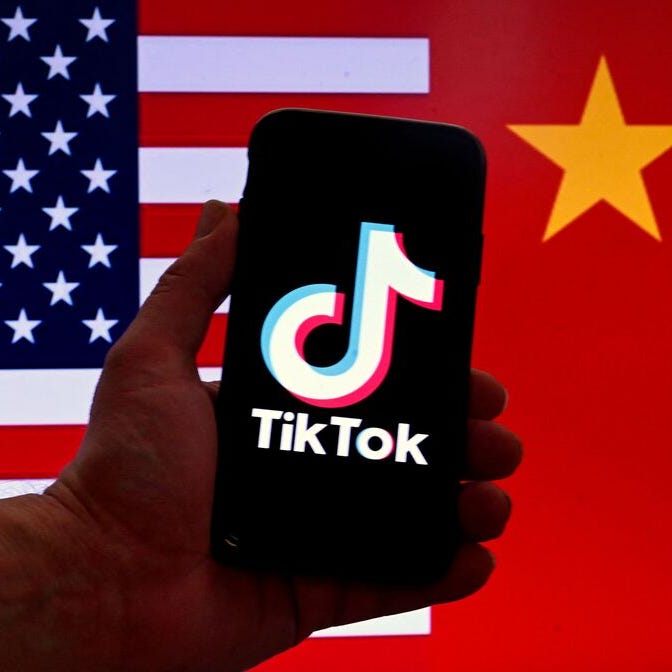 In this photo illustration the social media application logo for TikTok is displayed on the screen of an iPhone in front of a US flag and Chinese flag background in Washington, DC, on March 16, 2023.