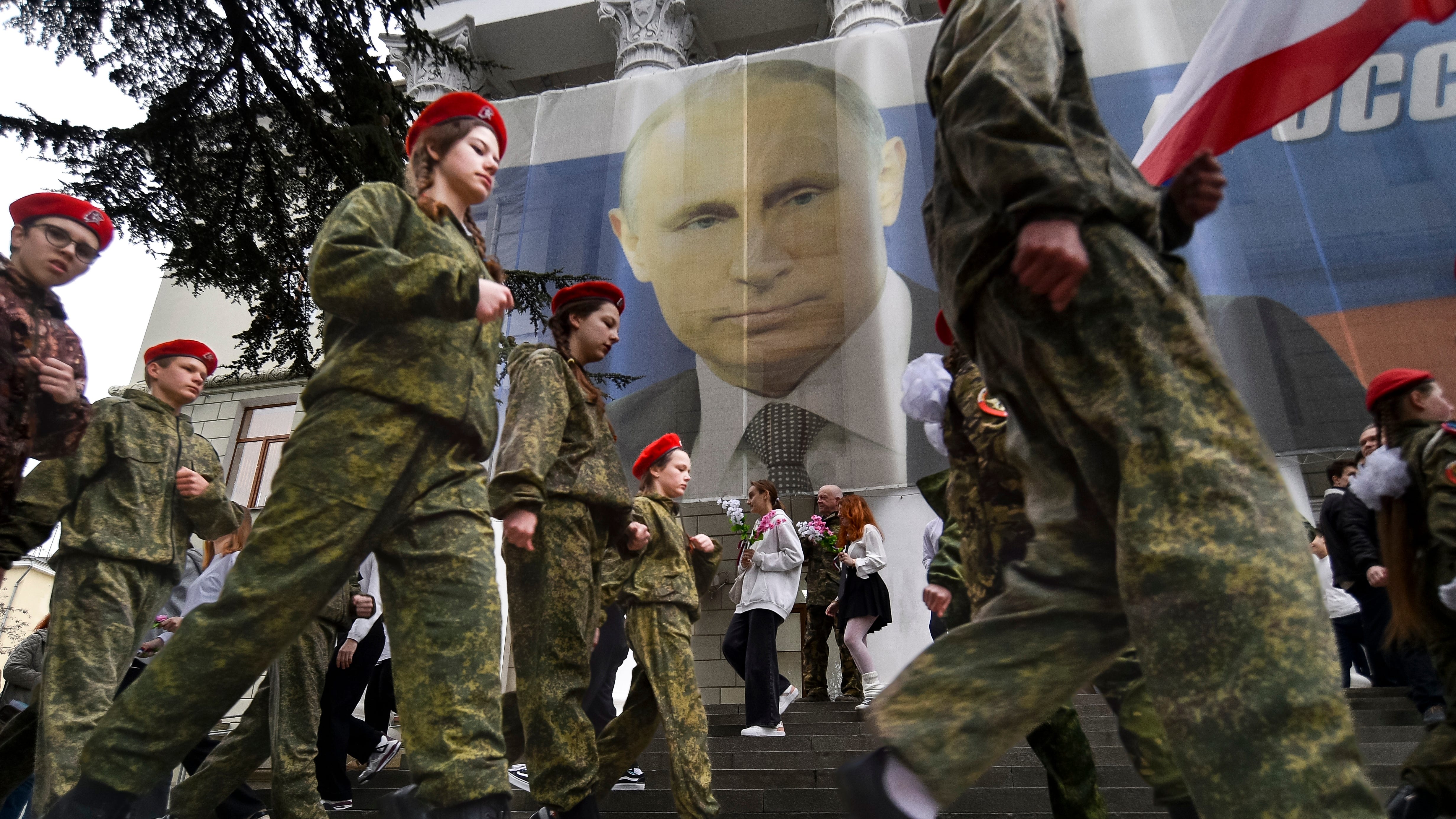 March 17, 2023: Youth take part in an action to mark the ninth anniversary of the Crimea annexation from Ukraine with the banner reading: "Russia doesn't start wars, it ends them" next to an image of Russian President Vladimir Putin in Yalta, Crimea, Friday, March 17, 2023.