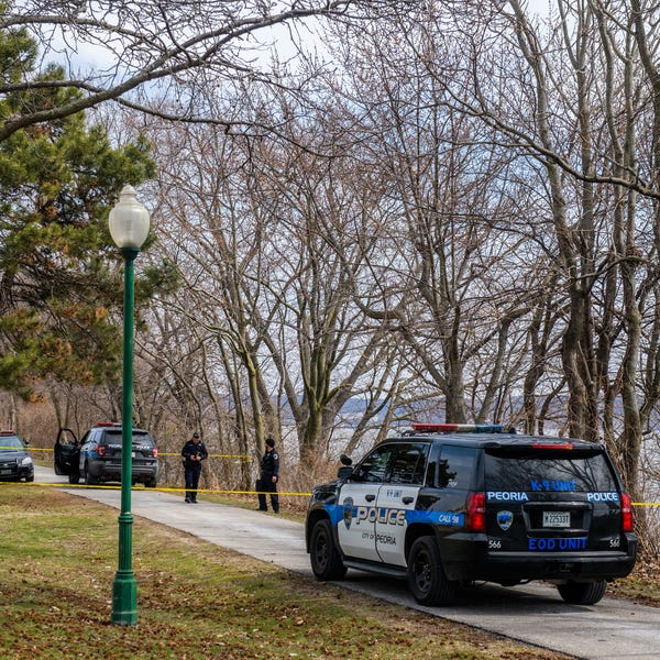 Peoria police officers investigate the area where a body was discovered Tuesday, March 21, 2023 in the Illinois River along the trail just north of the RiverPlex in Peoria.