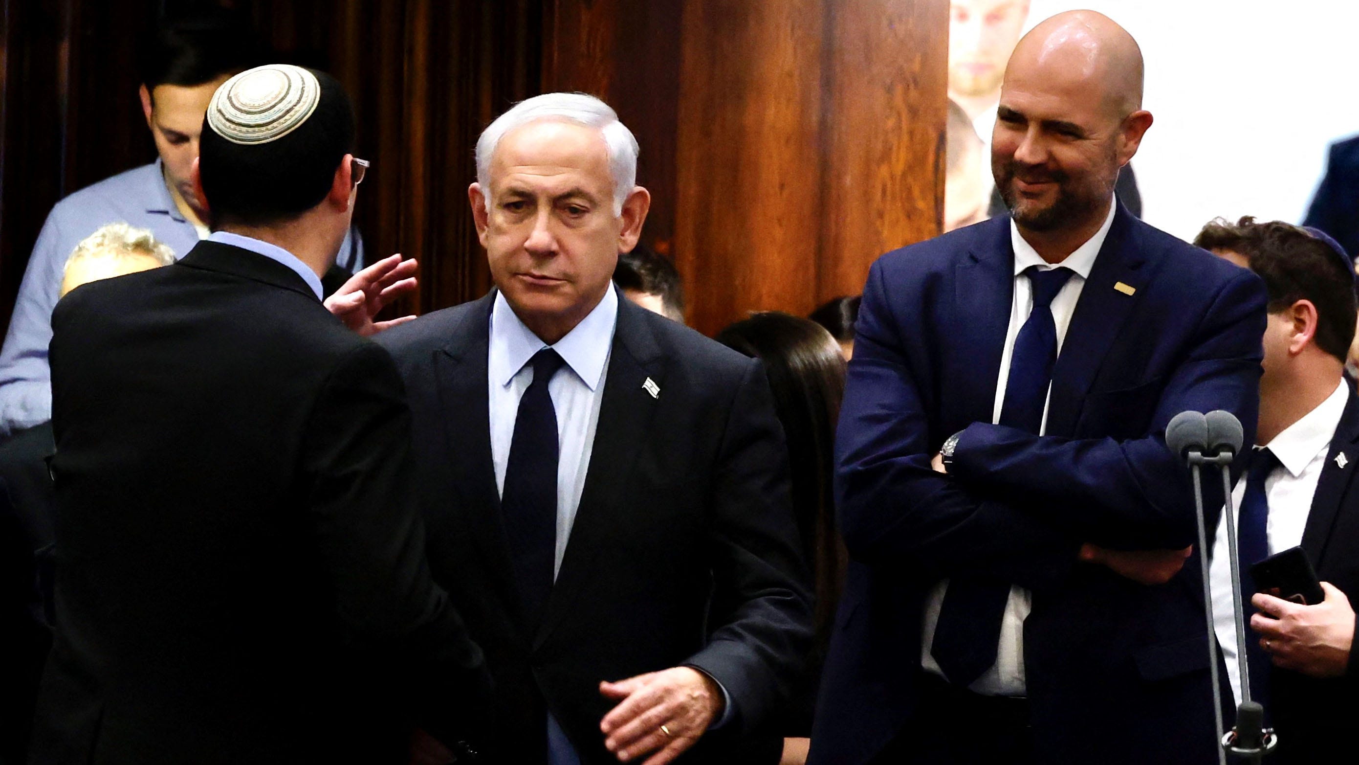 Israeli Prime Minister Benjamin Netanyahu (C) stands at the Knesset, Israel's parliament in Jerusalem, on March 27, 2023. Netanyahu announced a pause to divisive judicial reforms moving through parliament, after months of street rallies that drew tens of thousands.