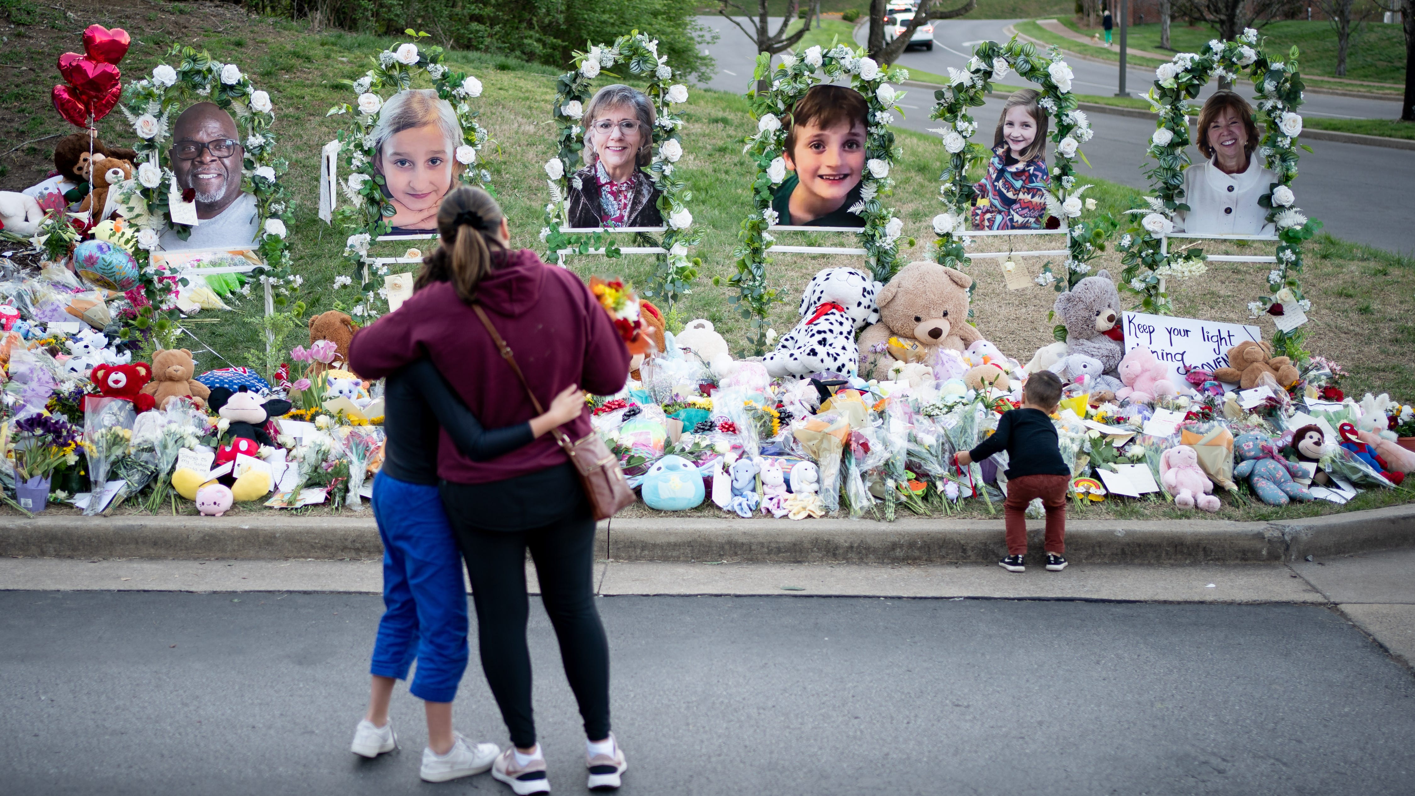 People gather at a memorial outside of Covenant School in Nashville, Tenn., Thursday, March 30, 2023. A shooting at the school on Monday left three adults and three children dead.