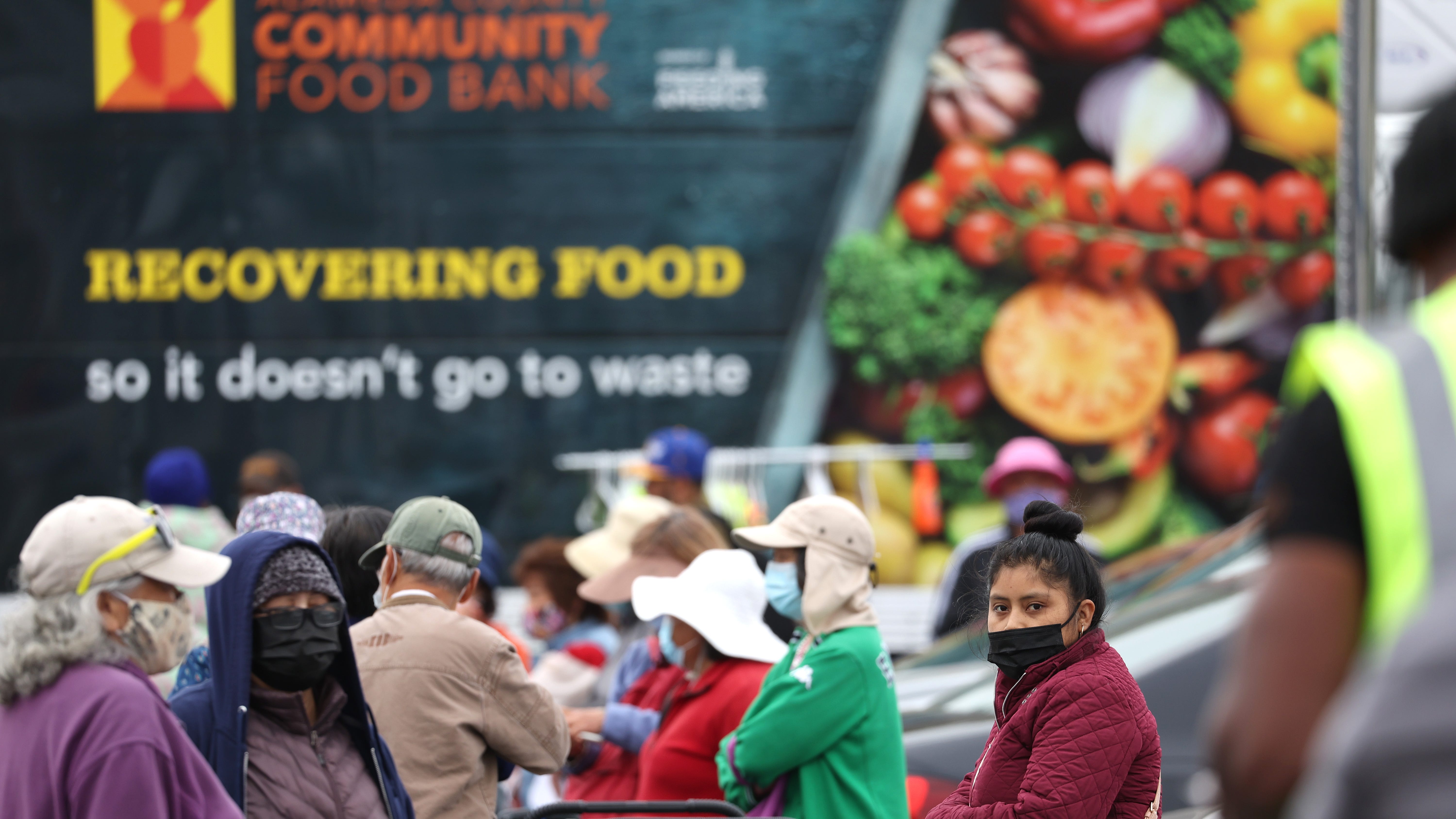 People wait in line at a food bank on July 15, 2022, in Oakland, Calif.