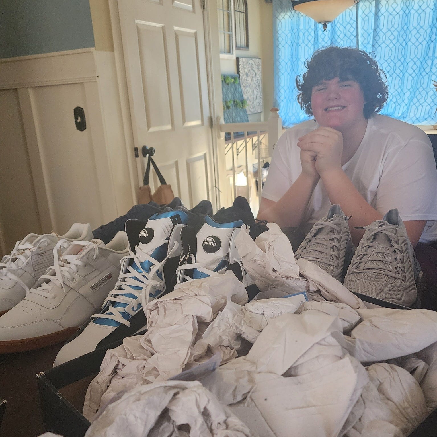 Eric Kilburn of Goodrich with a selection of Reebok size 22 shoes that were originally created for Shaquille O'Neal. The 14-year-old will wear these while awaiting larger shoes that are being custom made for him.