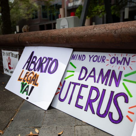 Dozens of signs opposing the six-week abortion ban line the sidewalk in front of the Tallahassee City Hall building on Monday, April 3, 2023.