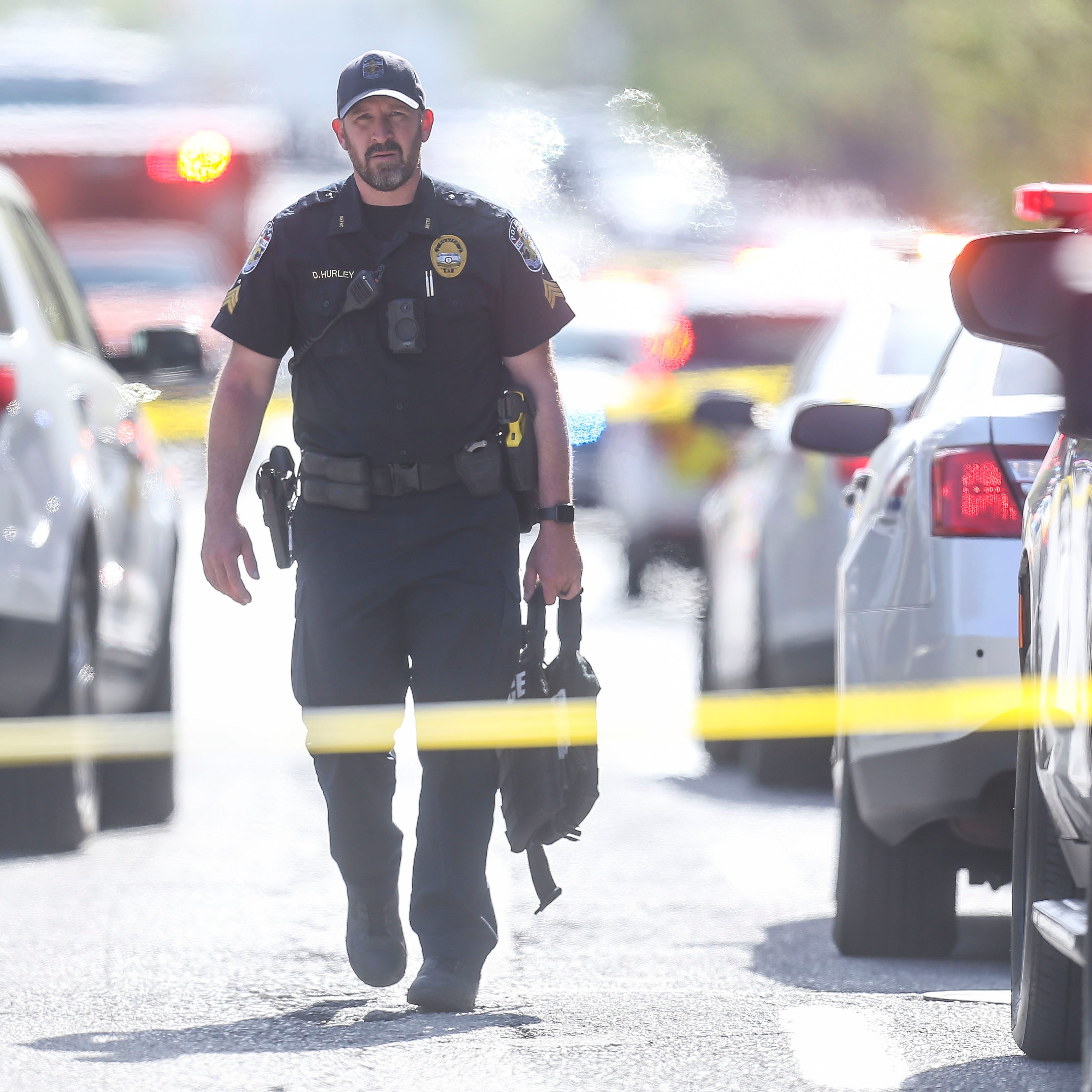 A Louisville Metro Police Department officer walks on Main Street  in downtown Louisville, Ky. outside Old National Bank Monday morning after four people were shot and killed, with eight injured including an LMPD officer. April 9, 2023