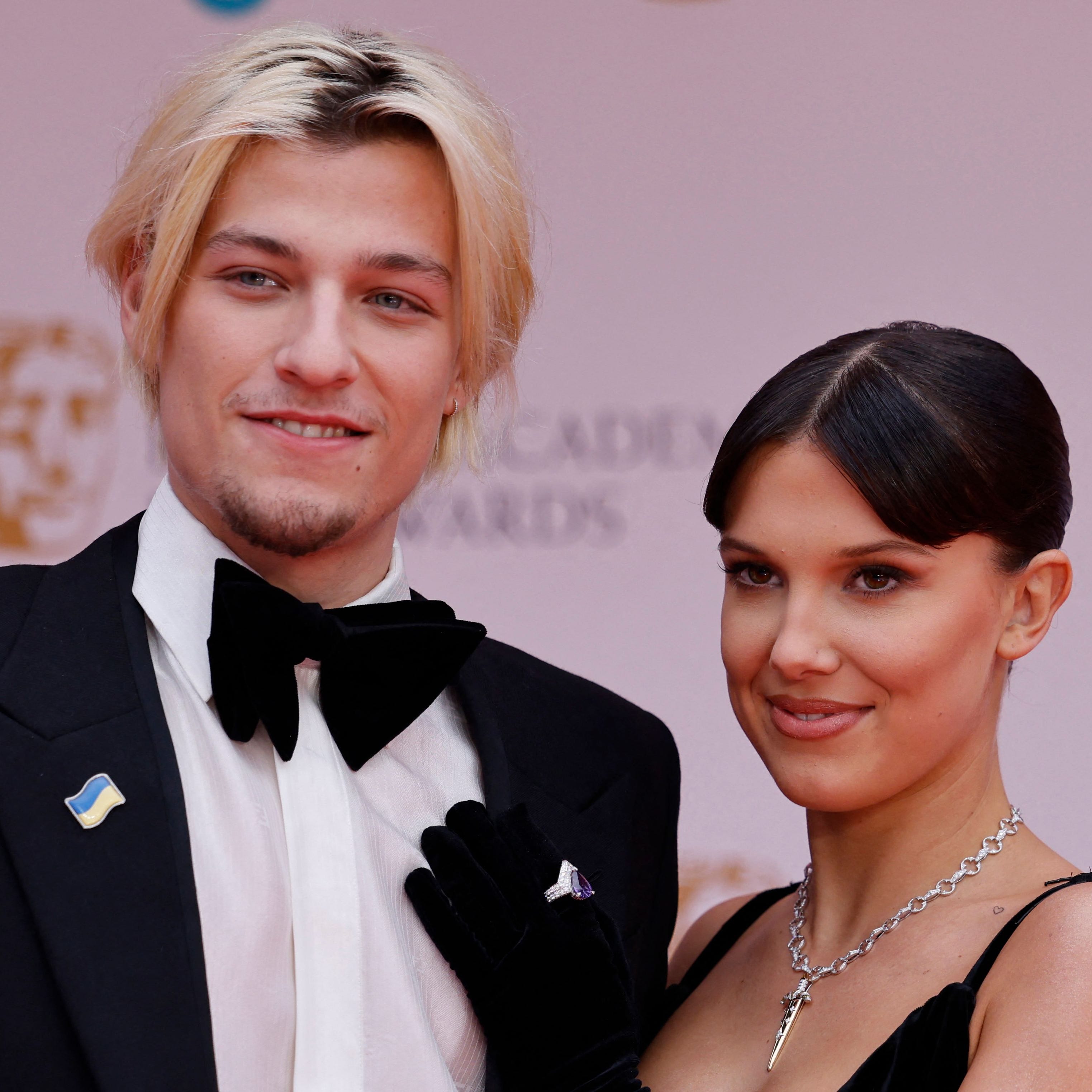 British actress Millie Bobby Brown (R) and companion pose on the red carpet upon arrival at the BAFTA British Academy Film Awards at the Royal Albert Hall, in London, on March 13, 2022. (Photo by Tolga Akmen / AFP) (Photo by TOLGA AKMEN/AFP via Getty Images) ORG XMIT: 0 ORIG FILE ID: AFP_3263739.jpg