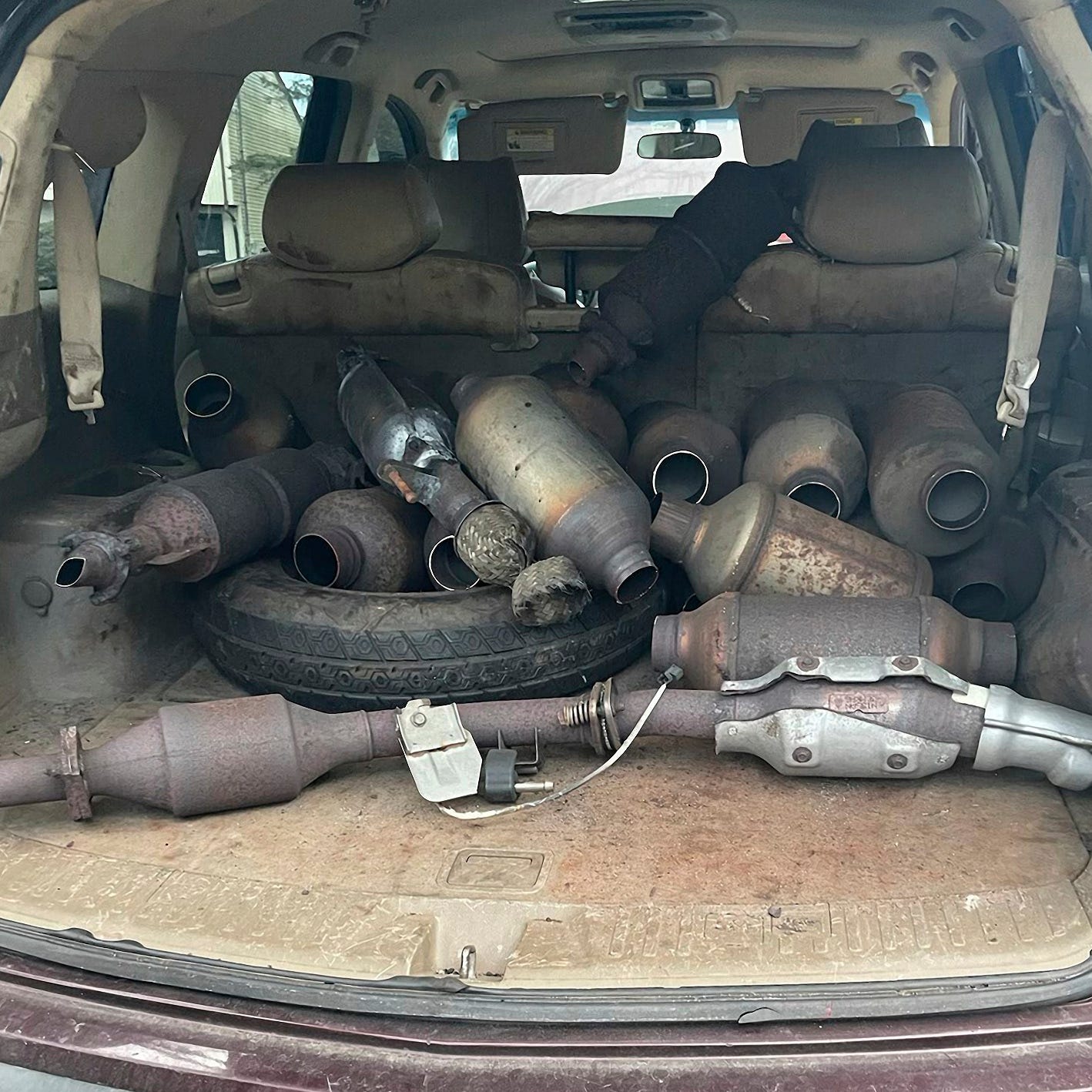 Several catalytic converters suspected stolen from vehicles in states including Massachusetts are piled in the back of an SUV. Seven men who authorities said worked with the speed and efficiency of a 