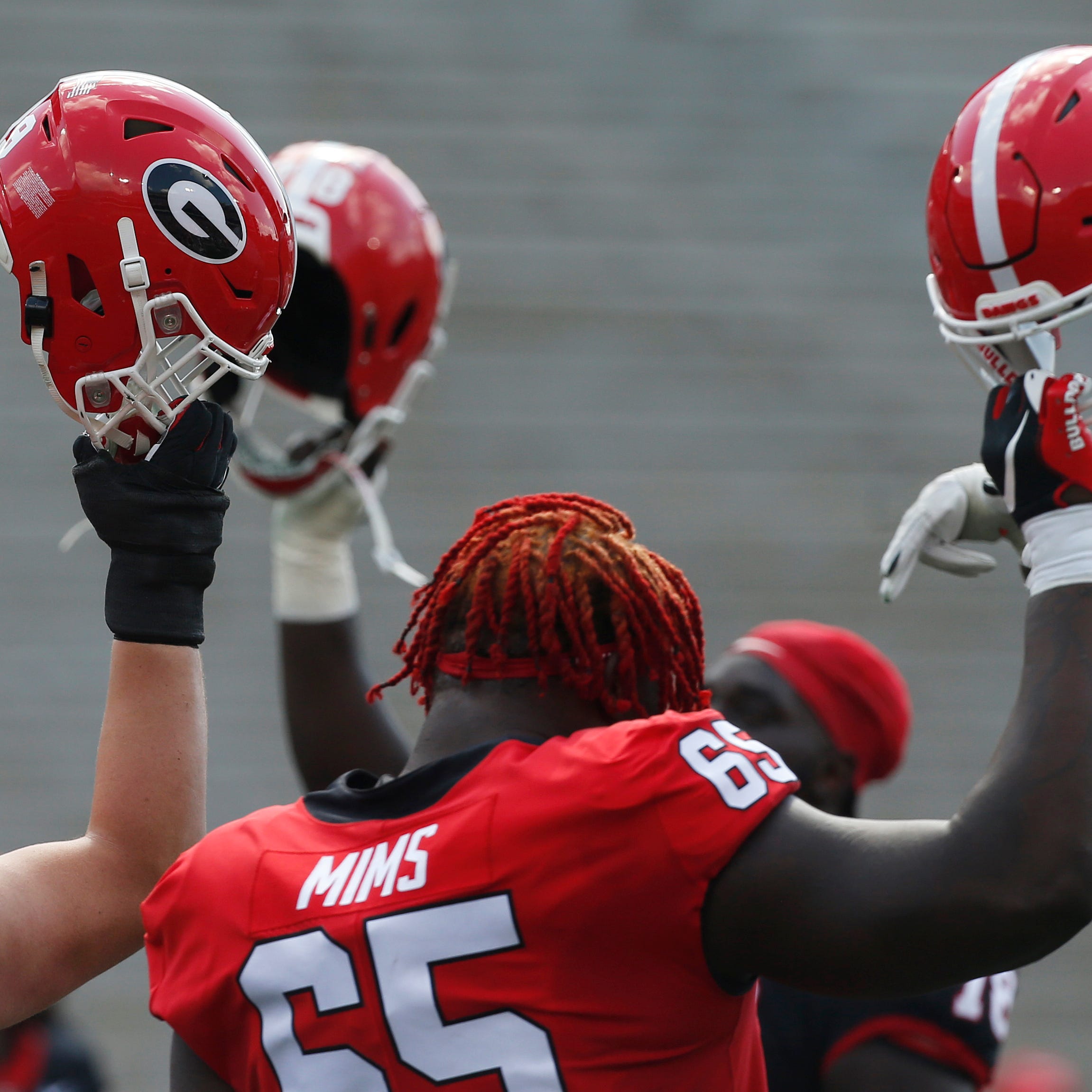 The red team takes a knee to start the game in honer of their lost teammates that died in a car crash the same week they won their second national championship during the UGA G-Day spring football game at Sanford Stadium in Athens, Ga., on Saturday, April 15, 2023.