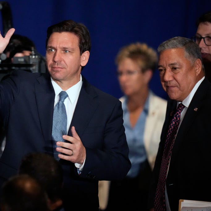 Florida Gov. Ron DeSantis, left, waves to the audience while arriving with Chris Ager, chairman of the New Hampshire Republican Party, during a stop at a New Hampshire Republican Party dinner, Friday, April 14, 2023, in Manchester, N.H.