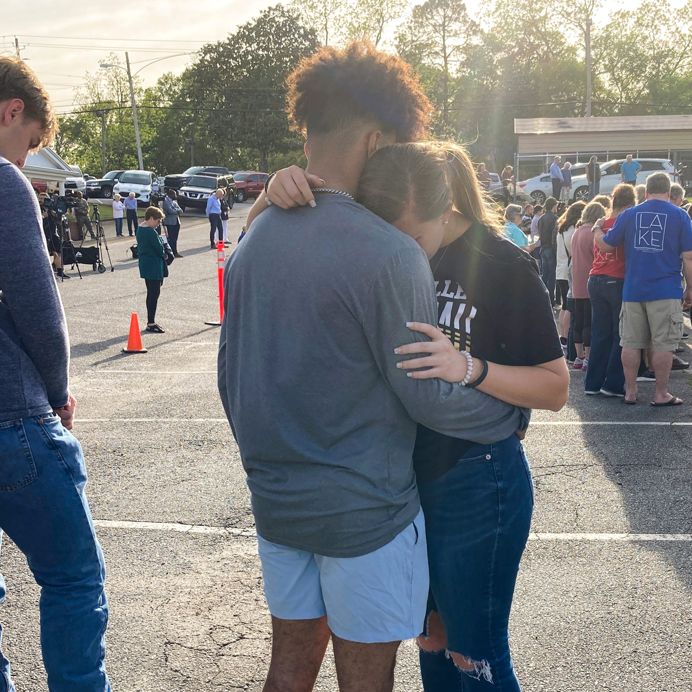 Two teens embrace at a prayer vigil on Sunday, April 16, 2023, outside First Baptist Church in Dadeville, Ala. Several people were killed and over two dozen were injured in a shooting at a teen birthday party in the town on Saturday, April 15. (AP Photo/Jeff Amy)