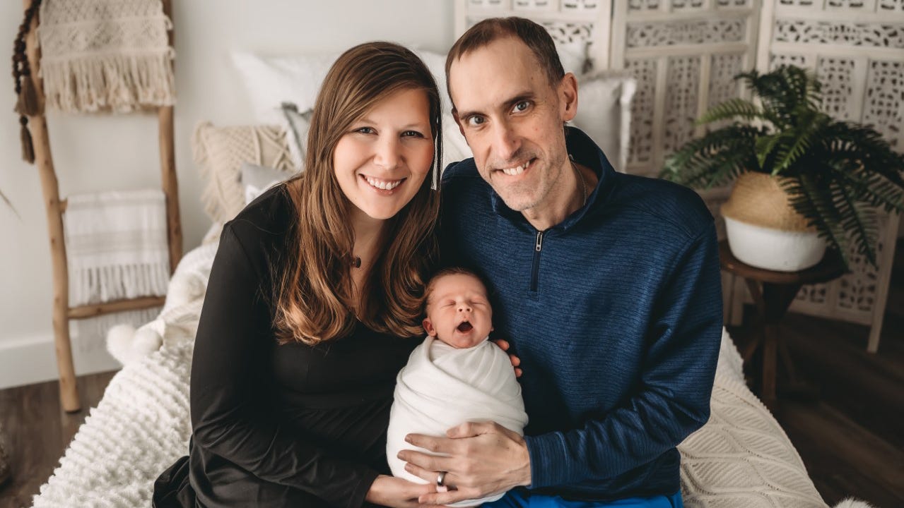 Rebecca and Tim Speck pose for a family photos with Thomas who was born just three months before Tim Speck died after a long battle with colon cancer.