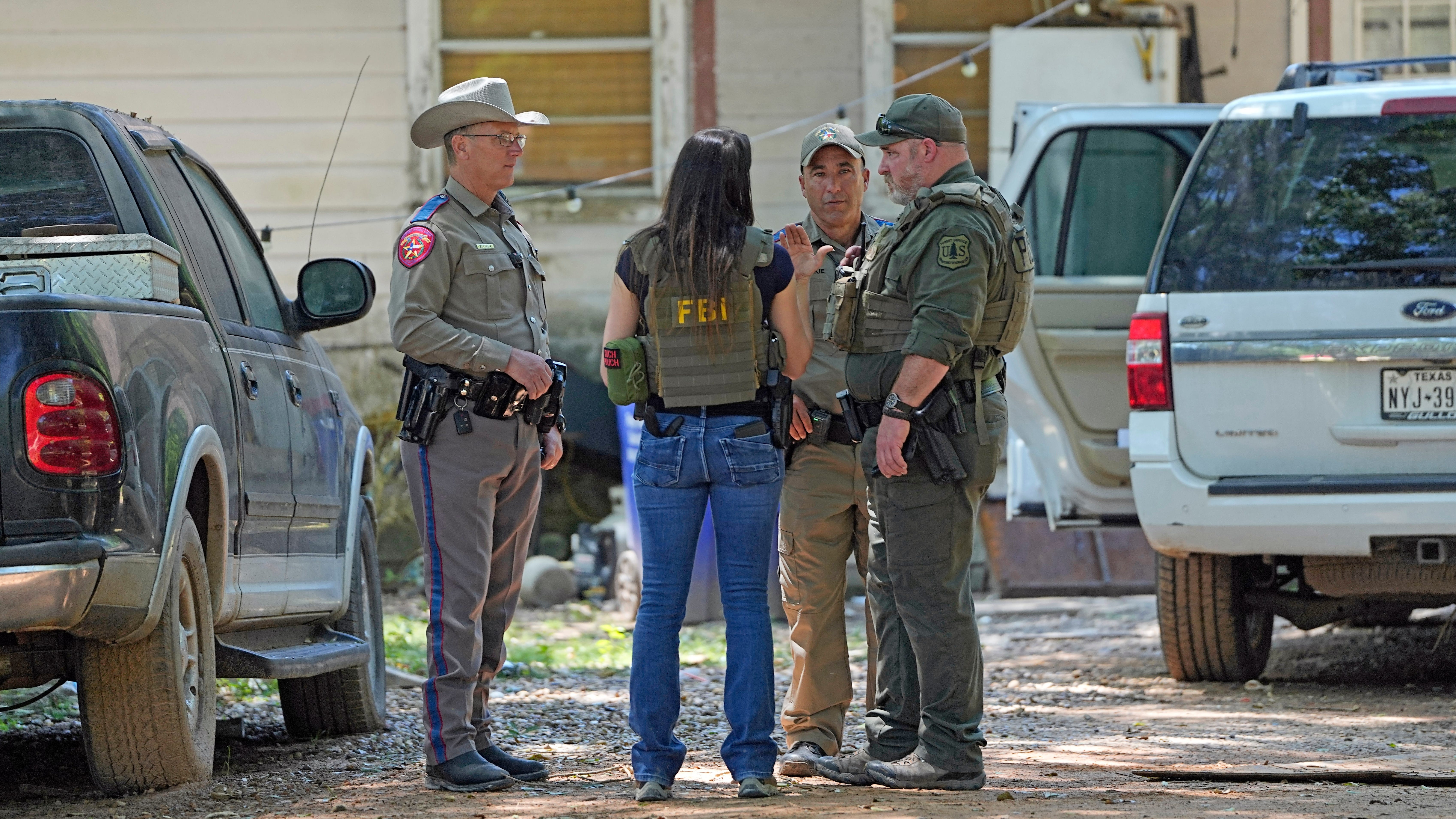 Law enforcement officials are pictured Sunday in the neighborhood where a deadly mass shooting occurred in Cleveland, Texas.