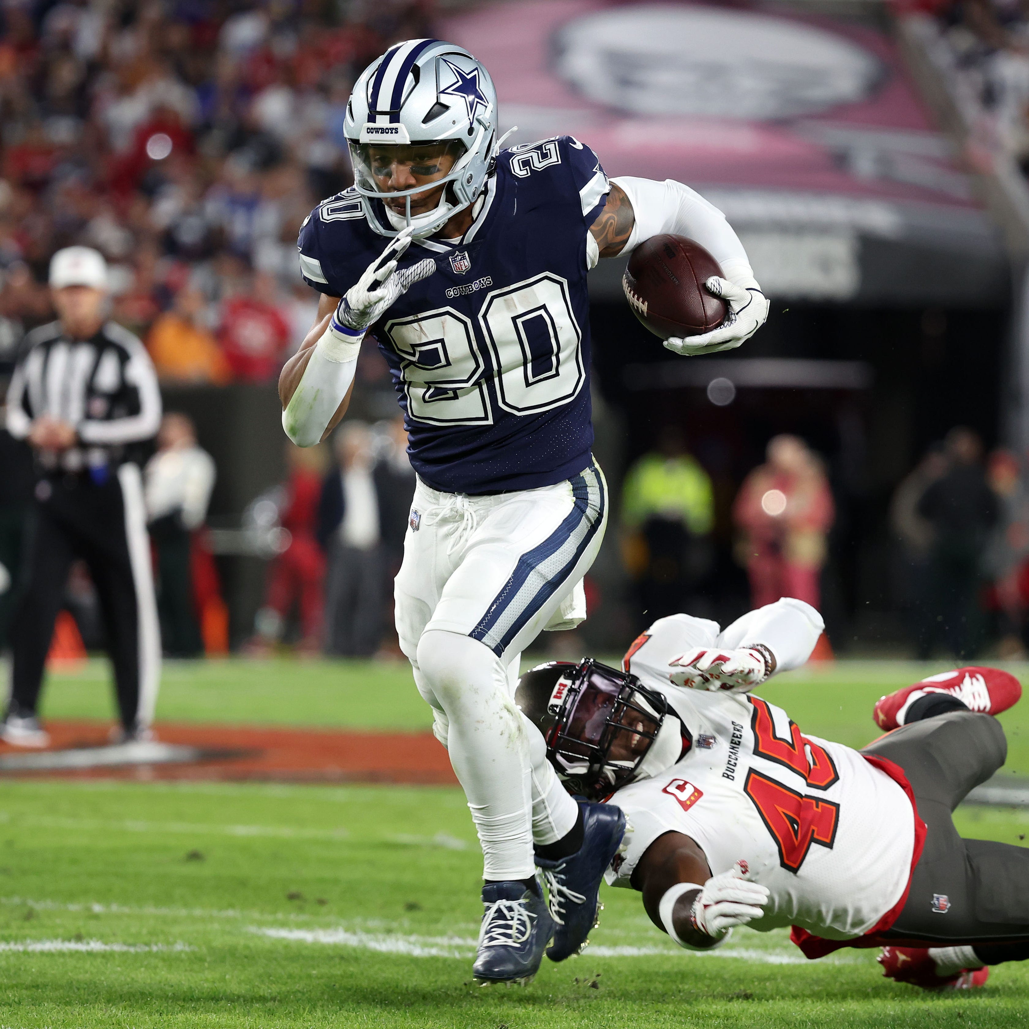 Dallas Cowboys running back Tony Pollard (20) breaks the tackle of Tampa Bay Buccaneers linebacker Devin White (45) in the first half during the wild card game at Raymond James Stadium.