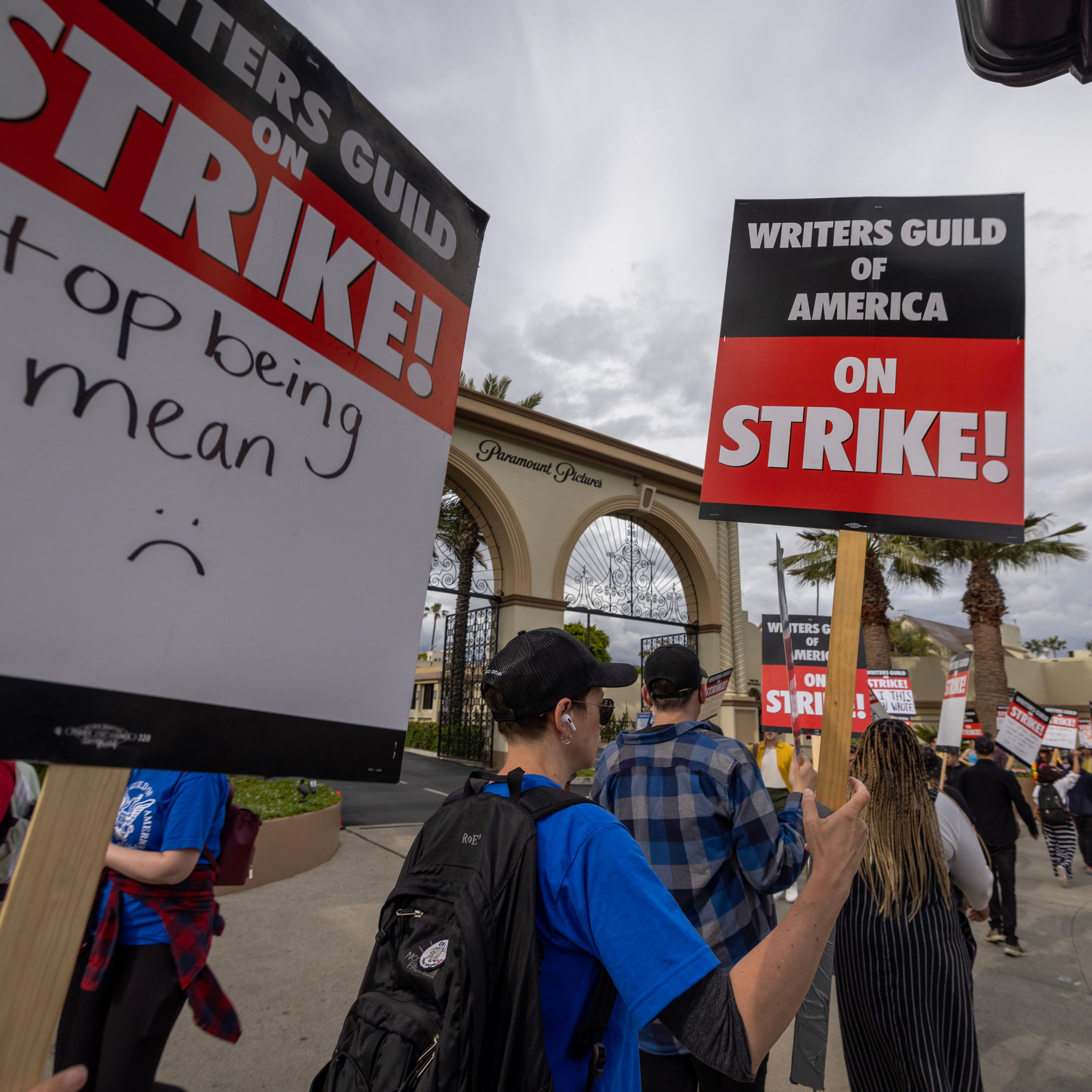 People picket outside of Paramount Pictures studios during the Hollywood writer's strike on May 4, 2023, in Los Angeles, California. Scripted TV series, late-night talk shows, film, and streaming productions are being interrupted by the Writers Guild of America (WGA) strike. In 2007 and 2008, a WGA strike shut down Hollywood productions for 100 days, costing the local economy between $2 billion and $3 billion.