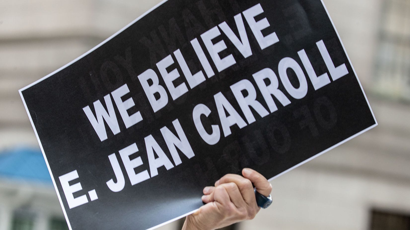 A protestor holds a sign outside the  federal courthouse in Manhattan May 9, 2023 after a jury found that former President Donald Trump sexually abused E. Jean Carroll in 1996. The jury also found Trump guilty of defamation and awarded Carroll $5 million.