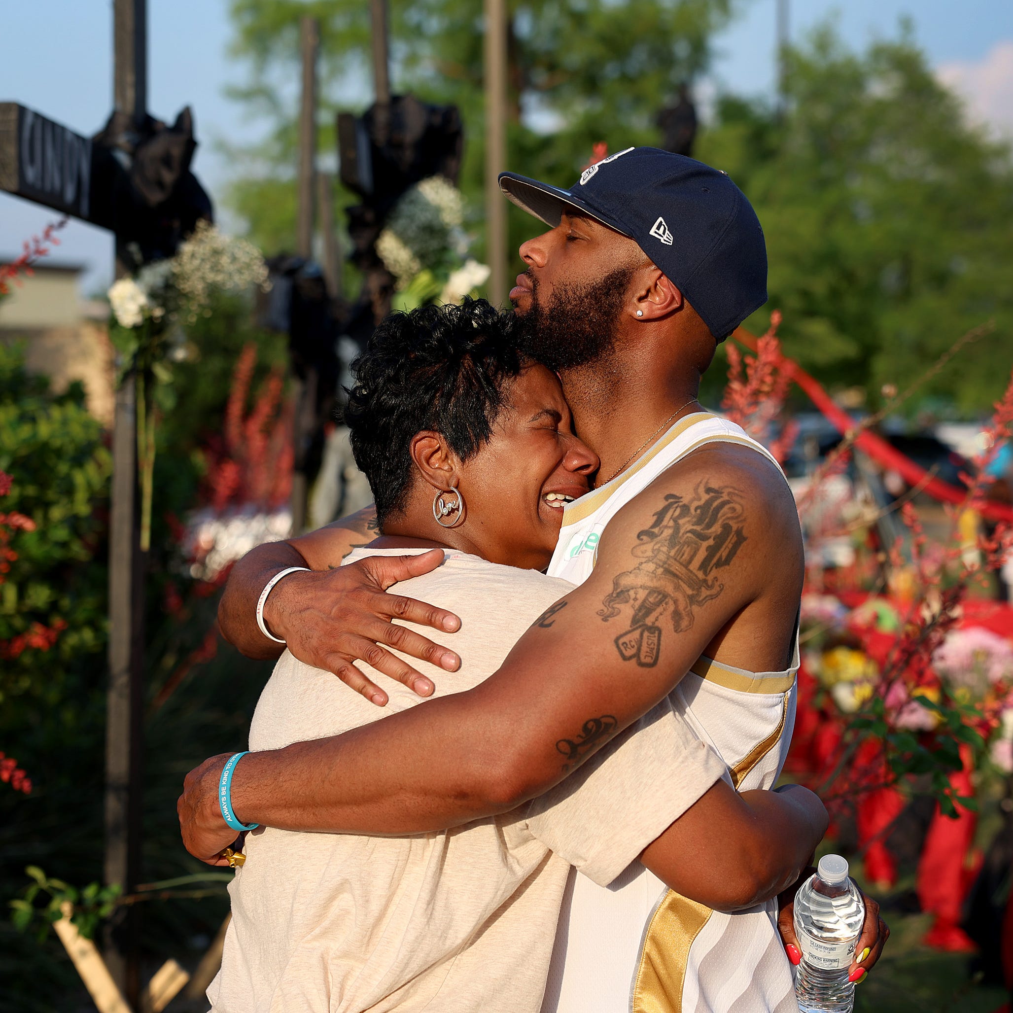 May 8, 2023: Robert Jackson comforts his mother Cheryl Jackson as they visit a memorial near the scene of a mass shooting at the Allen Premium Outlets mall in Allen, Texas. Eight people were killed and seven wounded in the Saturday attack in which the gunman was killed by police, according to published reports. Three of the wounded are in critical condition, according to the information.