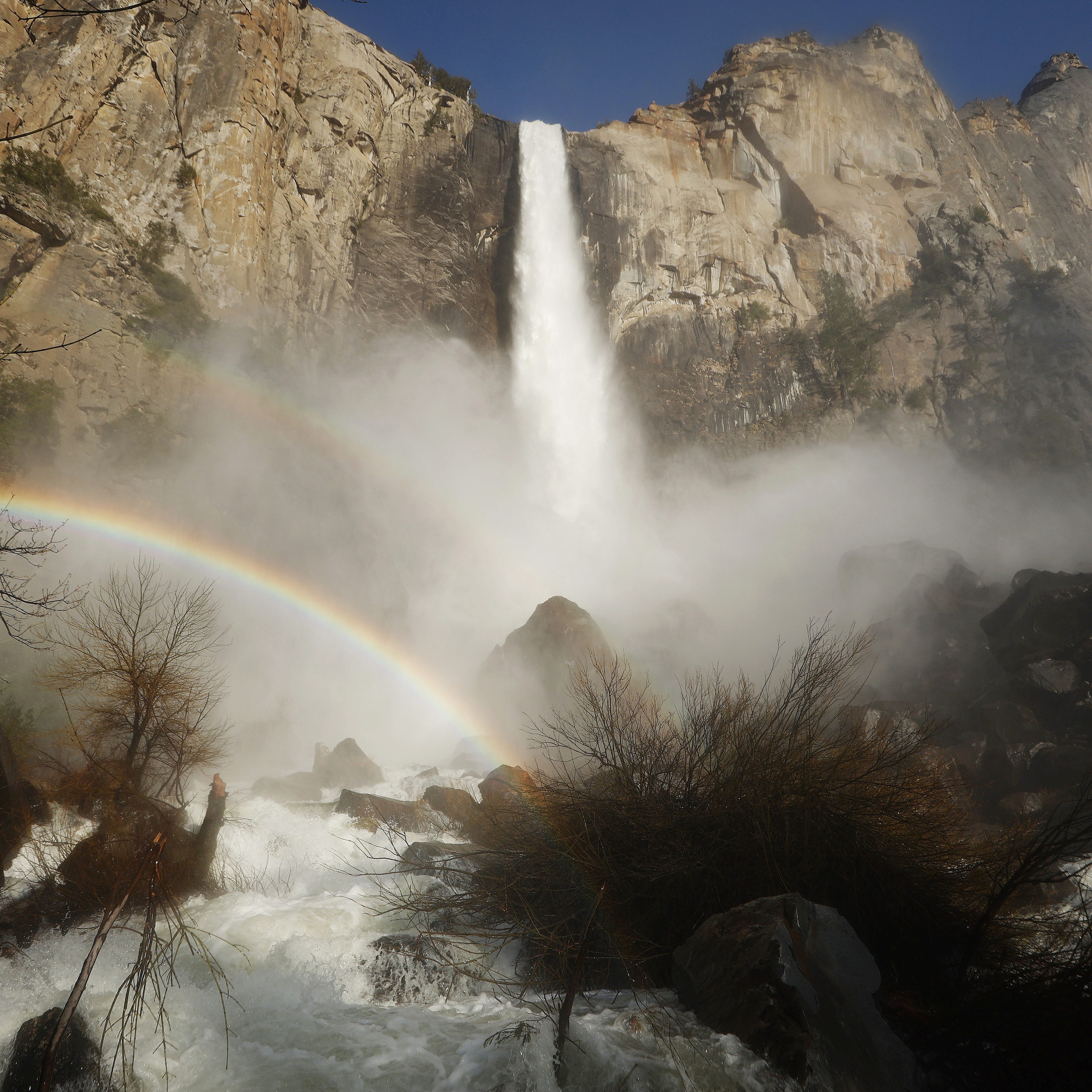 Water flows forcefully down Bridalveil Fall in Yosemite Valley, with rainbows visible in the mist, as warming temperatures have increased snowpack runoff, on April 27, 2023 in Yosemite National Park, California.