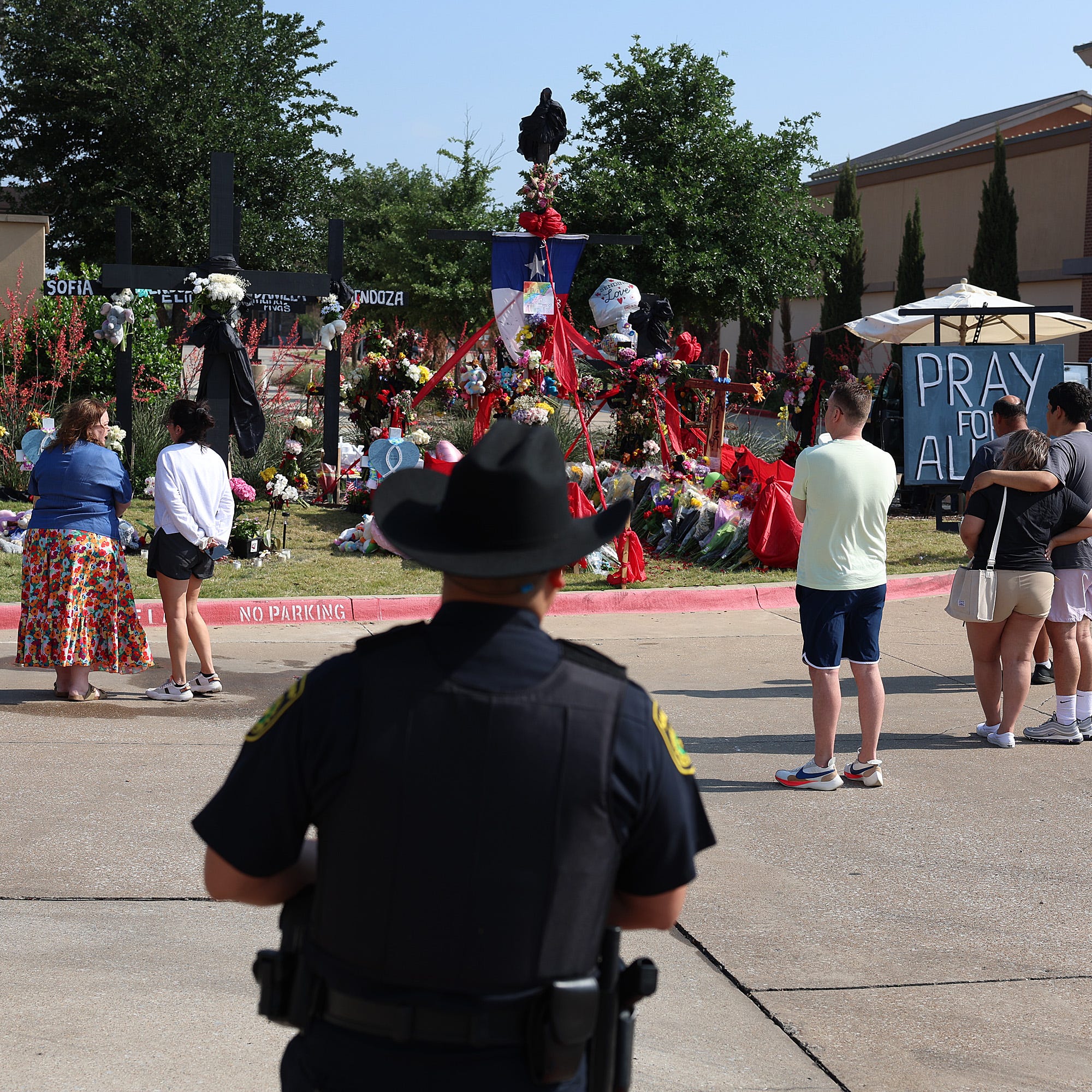 People visit a memorial near the scene of a mass shooting at the Allen Premium Outlets mall in Allen, Texas, May 9, 2023.