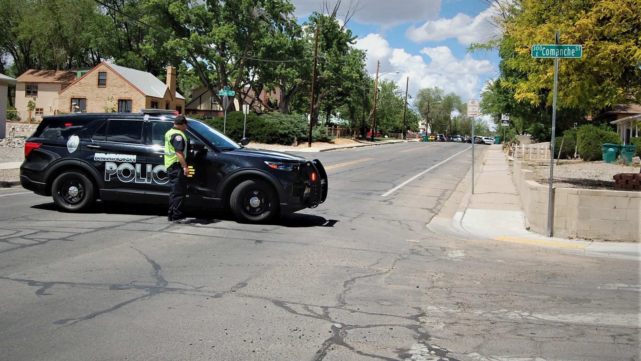 A Farmington police officer mans a roadblock at the corner of North Dustin Avenue and East Comanche Street on Monday, May 15 after a shooting in the area.