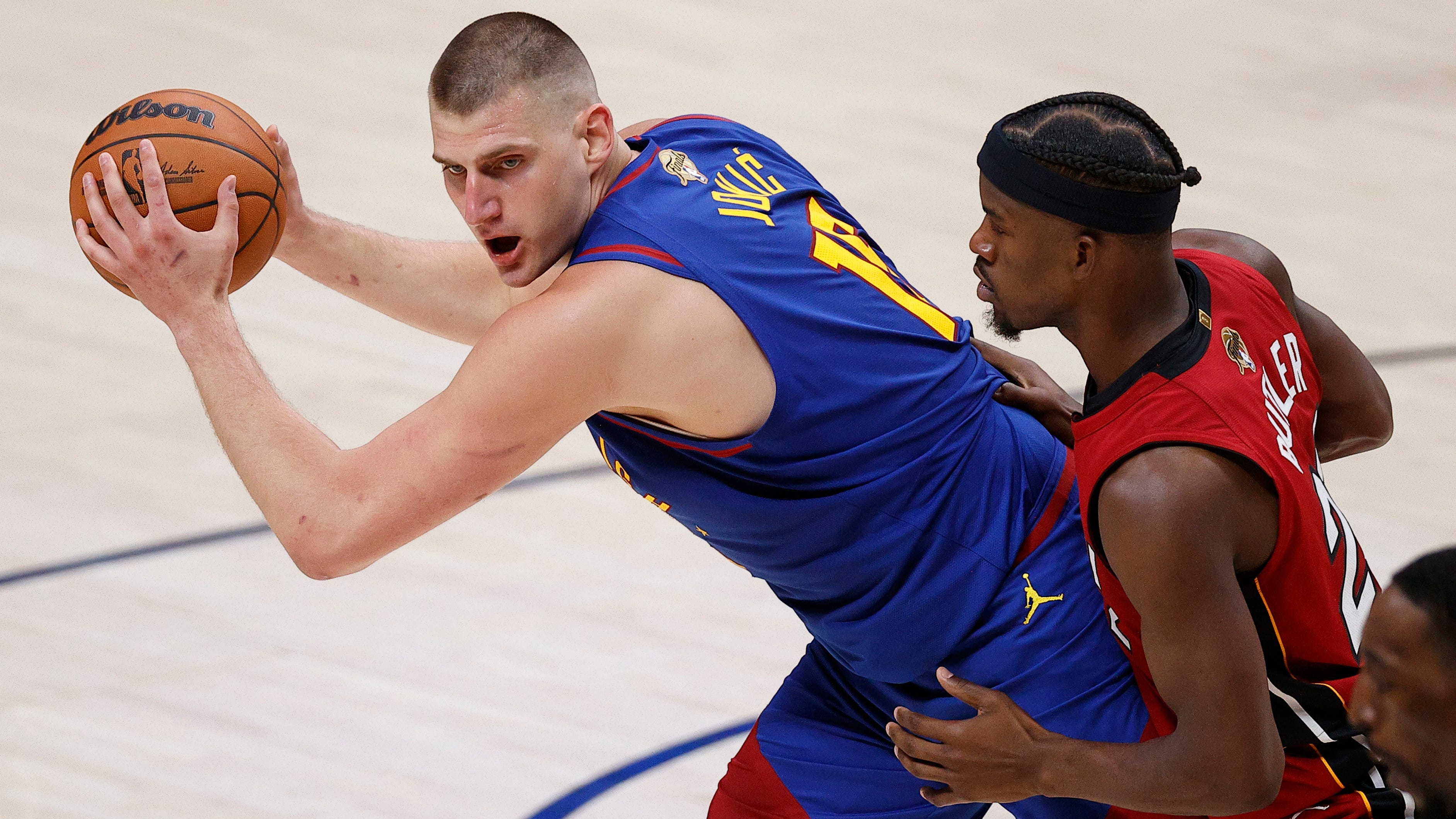 Nikola Jokic controls the ball while defended by Jimmy Butler during the second quarter in Game 1 of the 2023 NBA Finals.